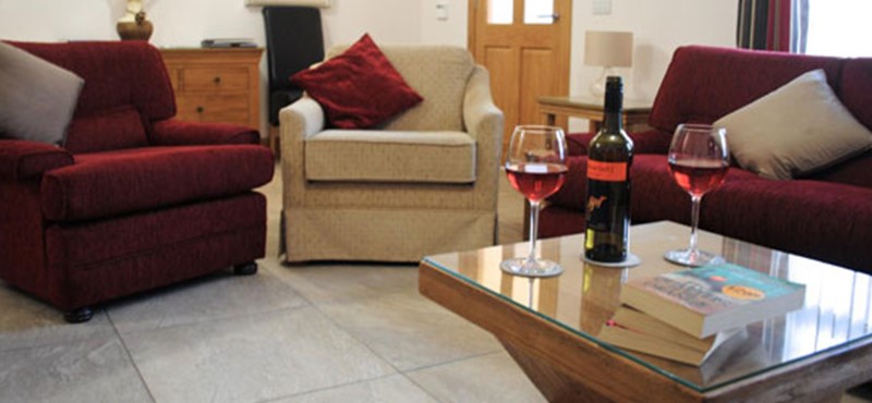 A photo of a living room with a bottle of wine on the table.
